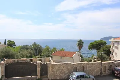 a stone wall with a view of the ocean at Apartman Ksjusa in Sutomore