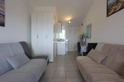 a living room with a couch and a kitchen at Apartman Ksjusa in Sutomore