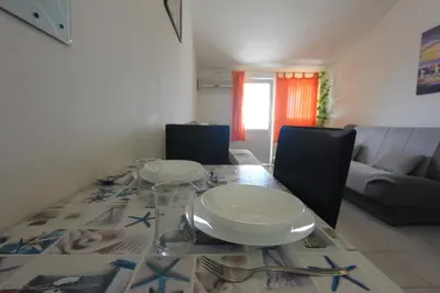 a dining room table with plates and glasses on it at Apartman Ksjusa in Sutomore
