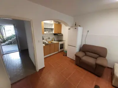 a kitchen with a chair and a white refrigerator at Two Bedrooms Apartment With Garden View in Budva