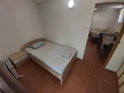 a small room with a bed and a table at Two Bedrooms Apartment With Garden View in Budva