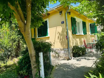 a yellow house with a table and chairs in front of it at Holiday Home Vesna in Budva