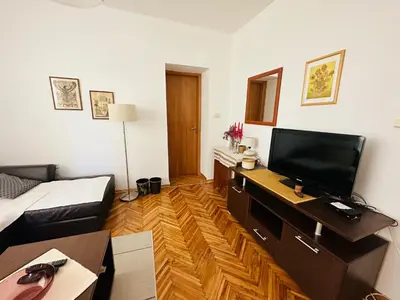 a living room with a flat screen tv on a desk at Holiday Home Vesna in Budva