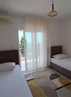 a bedroom with two beds and a view of a patio at Jasmin 4 in Ulcinj