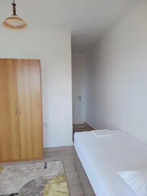 a bedroom with a white bed and a wooden cabinet at Jasmin 4 in Ulcinj