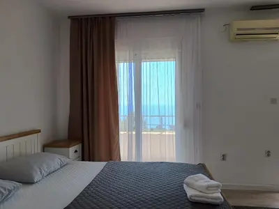 a bedroom with a bed and a large window at Suzana in Ulcinj