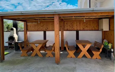 a picnic table and chairs under a pavilion at Apartmani Monić in Ulcinj