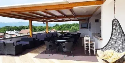 a patio with chairs and tables on a roof at Apartmani Monić in Ulcinj