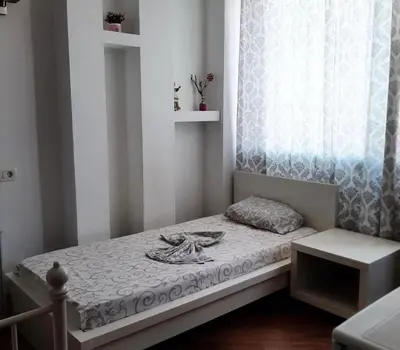 a small bedroom with a bed and a window at Apartmani Monić in Ulcinj