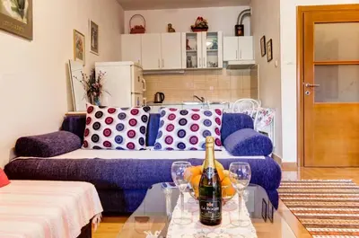 a living room with a couch and a table with wine bottles at Jelena in Budva