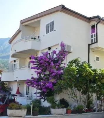 a white building with purple flowers in front of it at Villa ALEA in Dobra Voda
