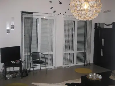 a living room with a chandelier and a chair at Villa ALEA in Dobra Voda
