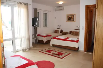 a hotel room with two beds and a television at Villa ALEA in Dobra Voda