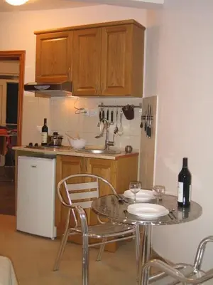 a kitchen with a table with two chairs and a counter top at Villa ALEA in Dobra Voda