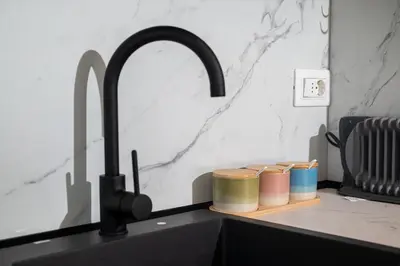 a kitchen counter with a black kitchen sink with a sink at Urban Coast - Ulcinj Apartment in Ulcinj