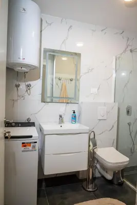 a white bathroom with a sink and a toilet at Urban Coast - Ulcinj Apartment in Ulcinj