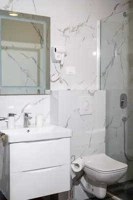 a white bathroom with a sink and a toilet at Urban Coast - Ulcinj Apartment in Ulcinj