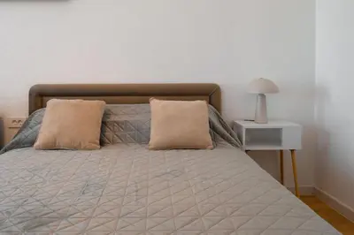 a bed with two pillows and a table with a lamp at Harmony Point in Bar