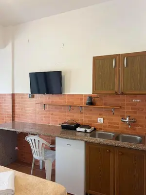 a kitchen with a sink and a tv on the wall at Enes Apartments in Ulcinj