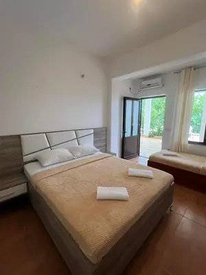 a bedroom with a large bed with two towels on it at Enes Apartments in Ulcinj