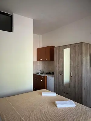a small room with two beds and a kitchen at Enes Apartments in Ulcinj