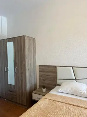 a bedroom with a bed and a wooden cabinet at Enes Apartments in Ulcinj
