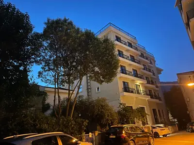 two cars parked in front of a tall building at Apartment ViSi 19 in Budva