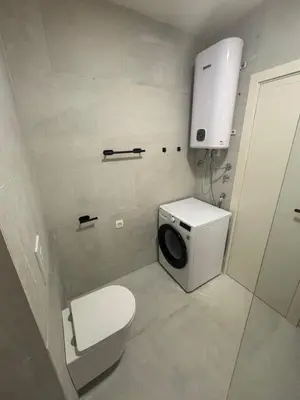 a bathroom with a toilet and a washing machine at Studio Sea View Steps to Przno beach w Parking Villa Olive in Pržno