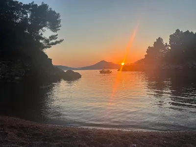 a sunset over a lake with a boat in the water at Studio Sea View Steps to Przno beach w Parking Villa Olive in Pržno