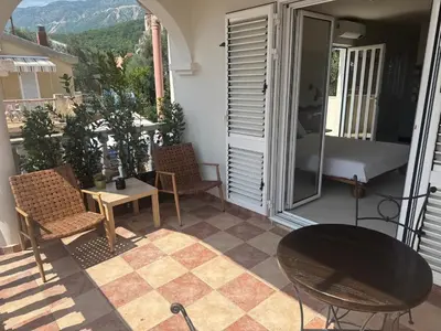 a patio with a table and chairs on a balcony at Studio Sea View Steps to Przno beach w Parking Villa Olive in Pržno
