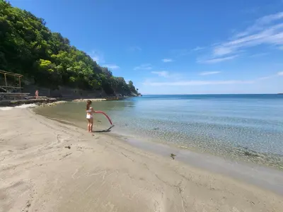 a little girl standing on a beach with a kite at MiLA - Hladna Uvala in Utjeha