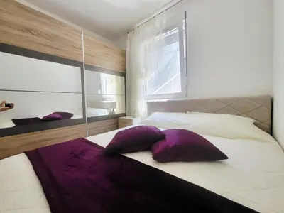 a bedroom with a large bed with purple pillows at MiLA - Hladna Uvala in Utjeha