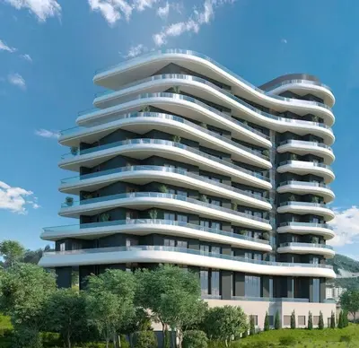 a large white building with trees in front of it at Montebay Apartment in Becici