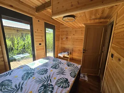 a bedroom with a bed in a wooden cabin at CabinAtRiver Ada Bojana in Ulcinj