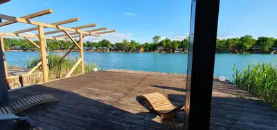 a deck with a chair and a view of a river at CabinAtRiver Ada Bojana in Ulcinj
