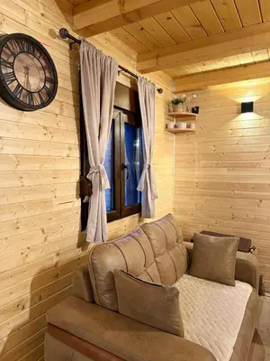 a living room with a couch and a clock on the wall at Mountain harmony Lovćen in Cetinje