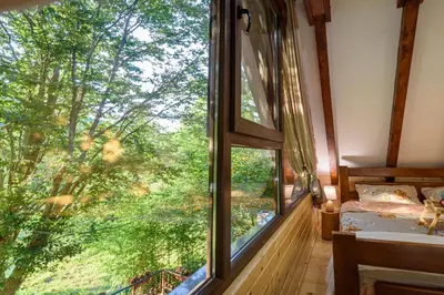 a bedroom with a large window in a tree house at Mountain harmony Lovćen in Cetinje