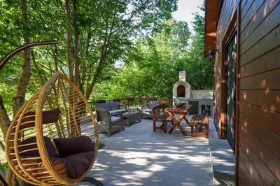 a porch with chairs and a hammock next to a house at Mountain harmony Lovćen in Cetinje
