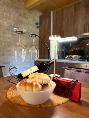 a bottle of wine and a bowl of food on a table at Mountain harmony Lovćen in Cetinje