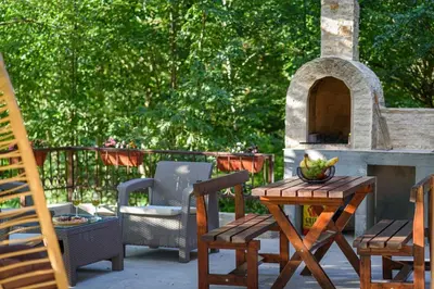 a patio with a table and chairs and a fireplace at Mountain harmony Lovćen in Cetinje