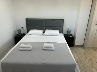 a bedroom with a large bed with two towels on it at Apartmani Filipovic in Podgorica