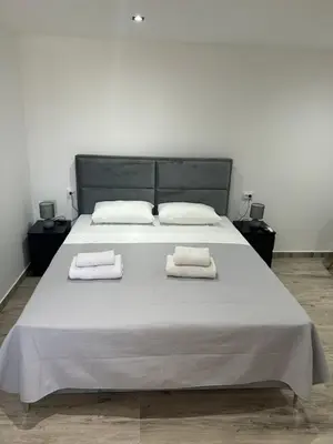 a bedroom with a large bed with two towels on it at Apartmani Filipovic in Podgorica