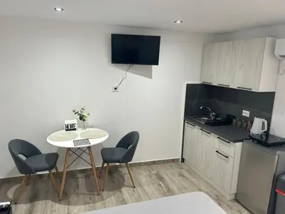 a kitchen with a table and chairs and a small table at Apartmani Filipovic in Podgorica
