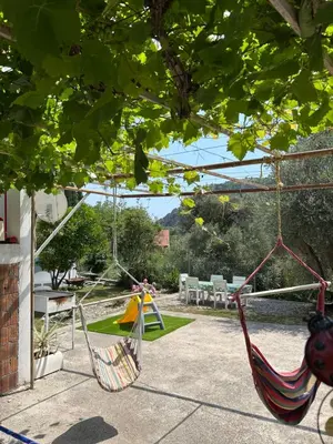 two hammocks in a garden with chairs and trees at Apartman Buljarica-Bačvice 1 in Petrovac na Moru