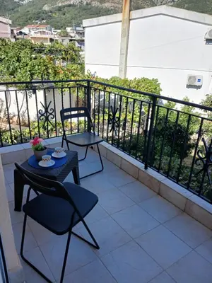 a balcony with a table and chairs on a balcony at Apartmani Bisser in Sutomore