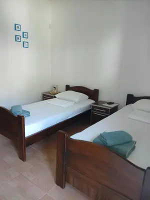 a room with two beds and two night stands at Apartmani Bisser in Sutomore