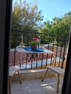 a table with two chairs and a plant on a balcony at Apartmani Bisser in Sutomore
