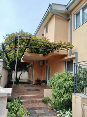 a house with a pergola in front of it at Apartmani Bisser in Sutomore
