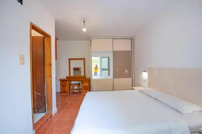 a bedroom with a large white bed and a mirror at Lana Apartments in Ulcinj