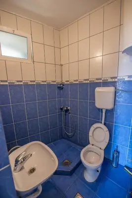 a blue and white bathroom with a toilet and a sink at Lana Apartments in Ulcinj